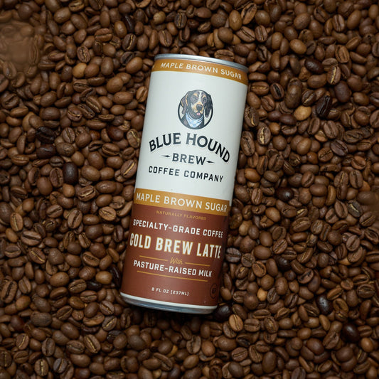 Blue Hound Coffee Cold Brew Latté can on a bed of coffee beans