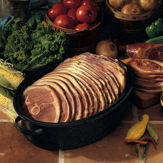 An image of Early's Honey Stand's Center Cut Country Ham, sliced thin and arranged on a plate surrounded by fresh vegetables. The ham is a rich, deep color and has a slightly crispy exterior. The vegetables include vibrant greens, reds, and yellows, providing a beautiful contrast to the ham's rich hue