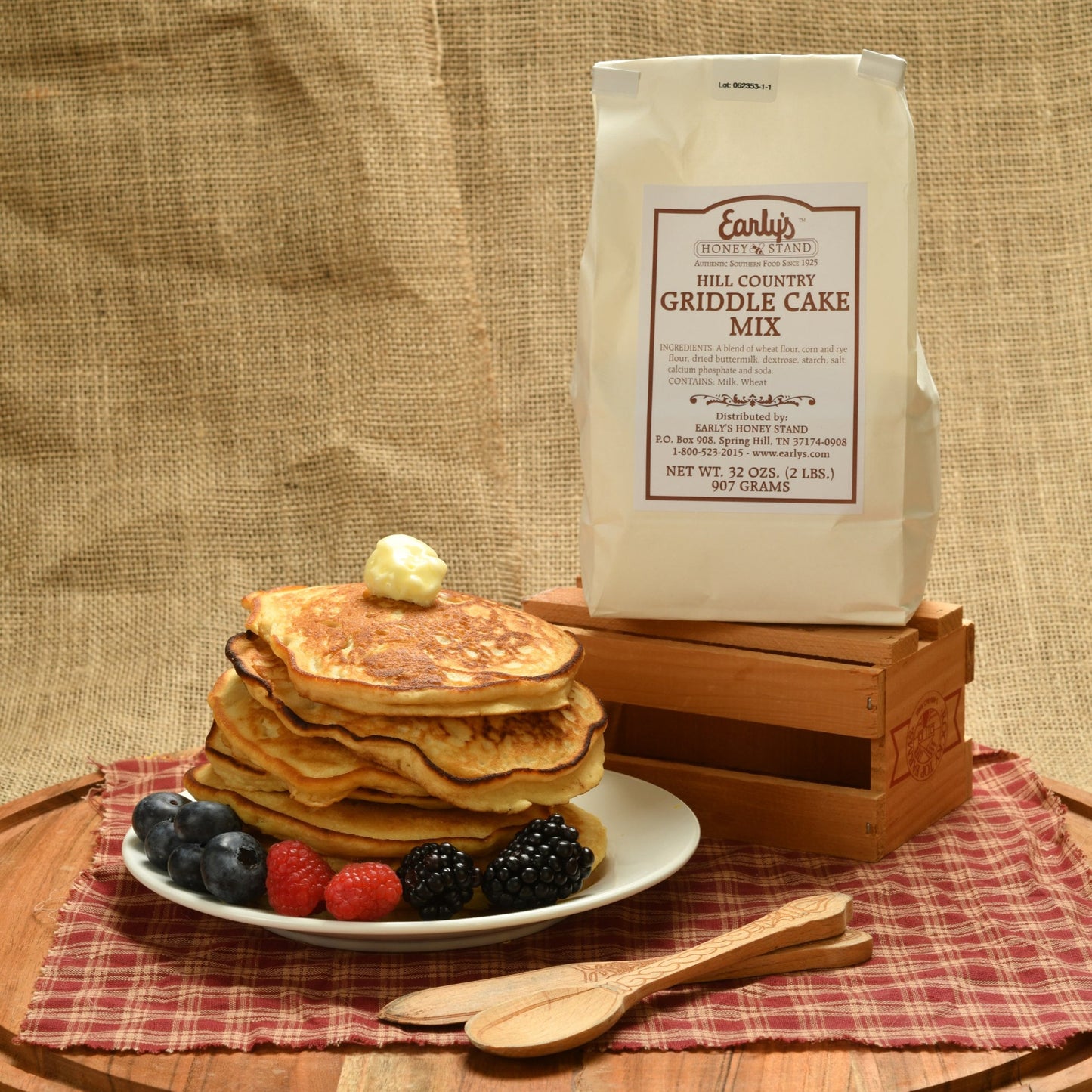 Early's Honey Stand all natural griddle cake mix pictured with a stack of griddle cakes and fruit. 